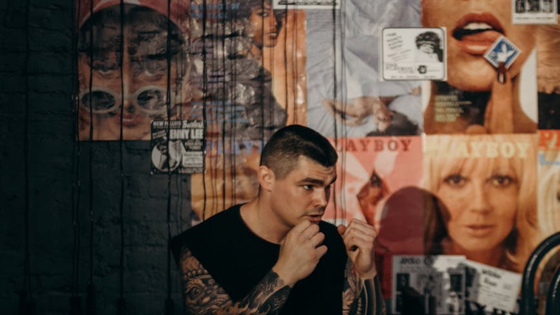 Man in a focused athletic stance in a dark, minimalist setting.